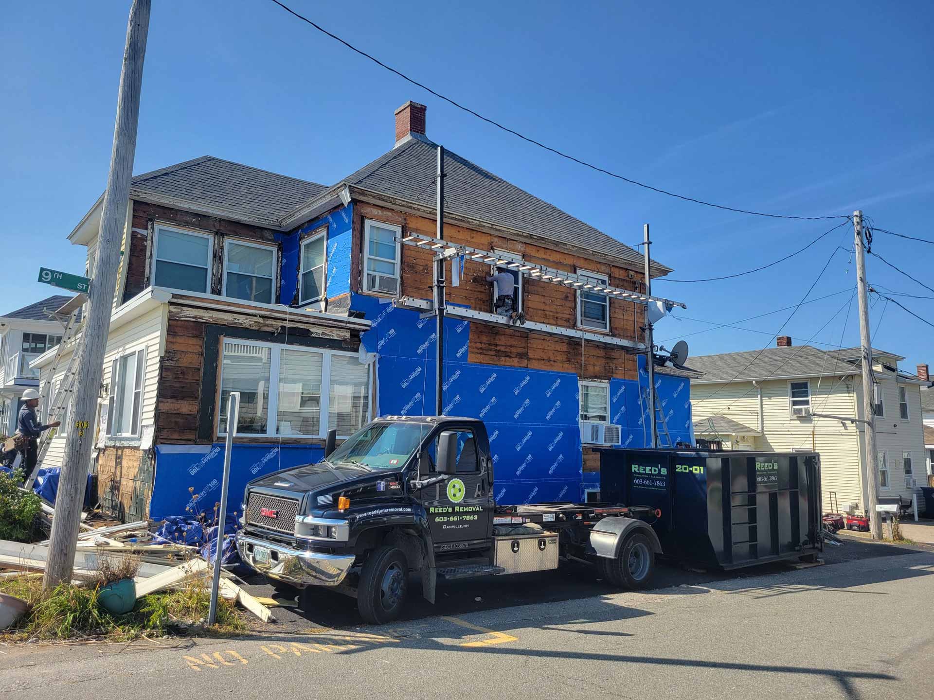 Reed's truck and dumpster parked outside of house during renovation