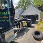 Rental dumpster from Reed's Demolition & Cleanouts LLC getting dropped off in driveway