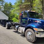 Reed's Demolition & Cleanouts LLC truck dropping off a rental dumpster