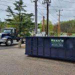 Rental dumpster from Reed's Demolition & Cleanouts LLC photographed with truck