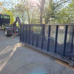 Rental dumpster from Reed's Demolition & Cleanouts LLC getting dropped off by truck