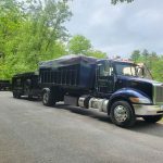 Reed's Demolition & Cleanouts LLC truck hauling two dumpsters