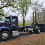 Reed's Demolition & Cleanouts LLC truck dropping off a rental dumpster